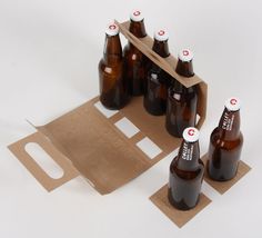 six brown beer bottles sitting next to each other on top of a piece of cardboard