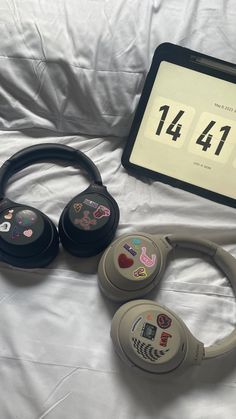 there are headphones and an electronic device on the bed with it's numbers