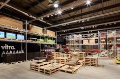 a room filled with lots of wooden pallets next to chairs and tables on top of each other