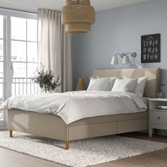 a bedroom with a bed, nightstands and two lamps on either side of the bed