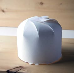 a white paper hat sitting on top of a wooden table