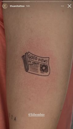 a person's arm with a newspaper tattoo that reads, good news on it