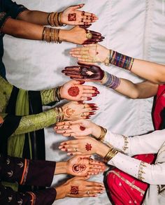 a group of women with their hands painted in hendi designs and bracelets on