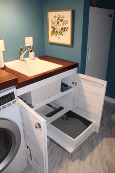 a washer and dryer in a small room next to a counter with an open drawer