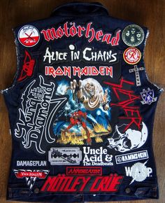 the back of a denim vest with patches and stickers on it, including an image of iron maiden