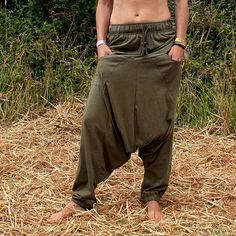 a shirtless man standing on top of dry grass