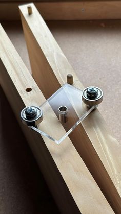 two metal knobs are attached to a wooden frame