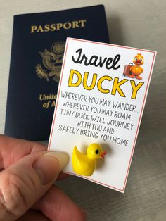 a person holding a yellow rubber ducky next to a passport