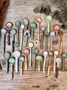 many spoons are lined up on a wooden table