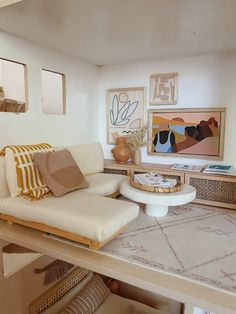 a living room filled with furniture and pictures on the wall next to a coffee table