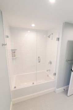 a white bathroom with a walk in shower next to a bath tub