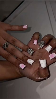 two hands with white and pink manies holding each other