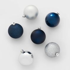 blue and white ornaments are arranged on a white surface