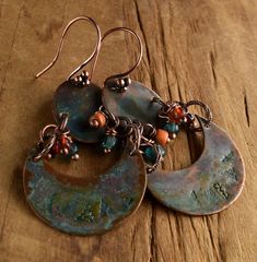 Primitive copper stamped two part connected earring design with crescent shaped lower and oval shaped upper components. The solid copper components are treated with a green patina and a coat of jewelry grade lacquer to protect the color. Dangles in sun drenched orange and watery blue add a touch of color. The solid copper earwires are a four ball cluster design, making the total length of the earrings 2.5 inches, and still a comfortable weight for their size. Your package will come to you gift w Bohemian Stamped Copper Jewelry, Green Copper Earrings With Patina, Primitive Jewelry, Copper Earrings Handmade, Patina Copper, Rustic Orange, Metal Stamped Jewelry, Paper Bead Jewelry, Earthy Jewelry