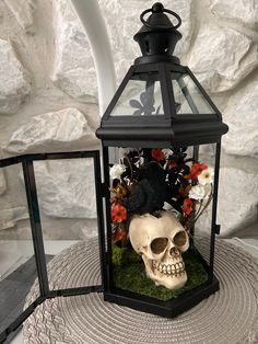 a fake human skull in a lantern with flowers