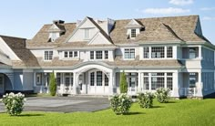 a large white house sitting on top of a lush green field