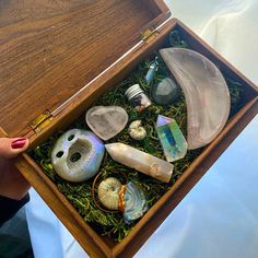 a wooden box filled with lots of different types of rocks and seashells in it