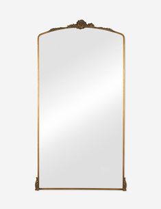 a large gold framed mirror with an ornate design on the top and bottom edge, against a white background