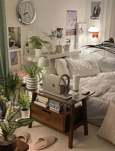 a bed room with a neatly made bed and lots of plants on the side table