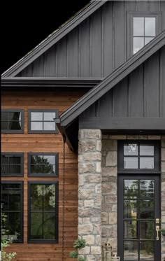 the front entrance to a house with black doors and windows