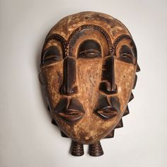 a wooden mask hanging on the wall