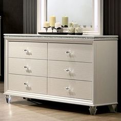 a white dresser with candles on top of it