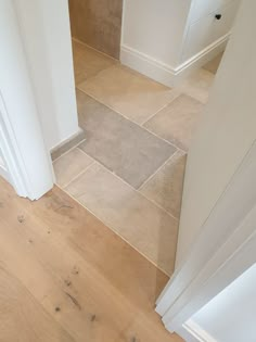 an empty bathroom with wooden floors and white walls