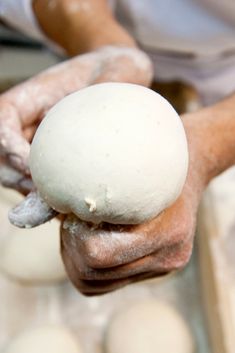 a person holding a ball of dough in their hands