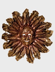 a gold sun face is shown against a white background