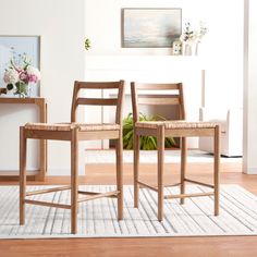 two wooden chairs sitting on top of a white rug