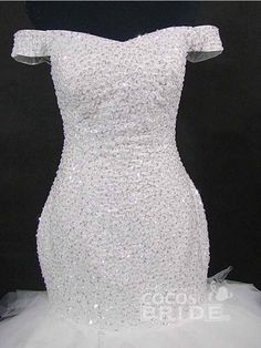 a white wedding dress on display in front of a black background