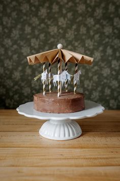 a chocolate cake topped with umbrellas on top of a wooden table