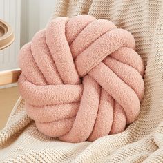 a pink ball of yarn sitting on top of a chair