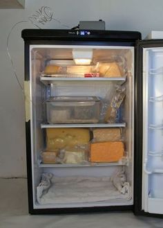 an open refrigerator with cheese and other food in it