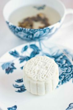 a white and blue plate topped with cookies next to a bowl filled with soup or tea