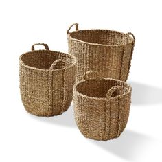 three woven baskets with handles and handles on the sides, one is brown in color