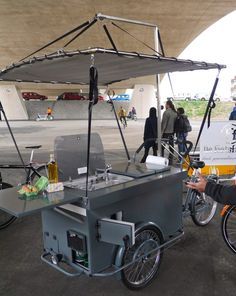 a man standing next to a cart with food on it