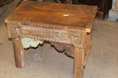 an old wooden table with carvings on the top and bottom, sitting in a room