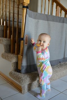 a baby standing on the stairs playing with something