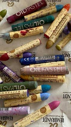 many crayons are lined up on the table and one has writing on it