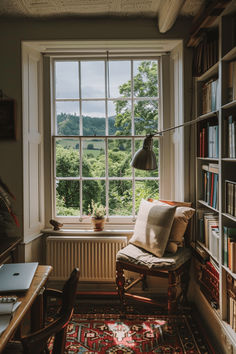 a chair sitting in front of a window next to a book shelf filled with books