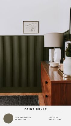 an image of a room with green paint on the walls and wood furniture in the foreground