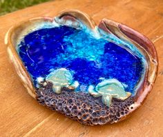 a blue and brown object sitting on top of a wooden table with grass in the background