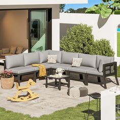 an outdoor living area with grey couches and tables