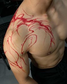 a man with red paint on his arm and chest