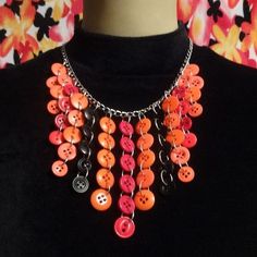 an orange and black necklace with buttons on it