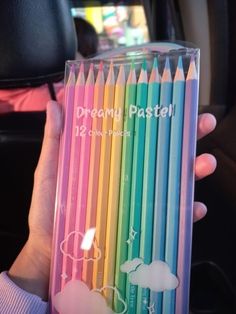 a person holding several colored pencils in their hand, with the words dream pastel written on them