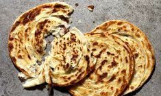 four pieces of flat bread on a gray surface