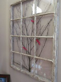 an old window is decorated with branches and birds