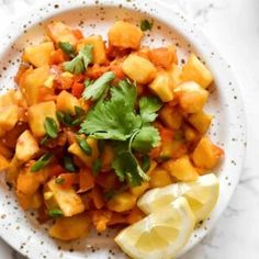 a white plate topped with pineapple and cilantro